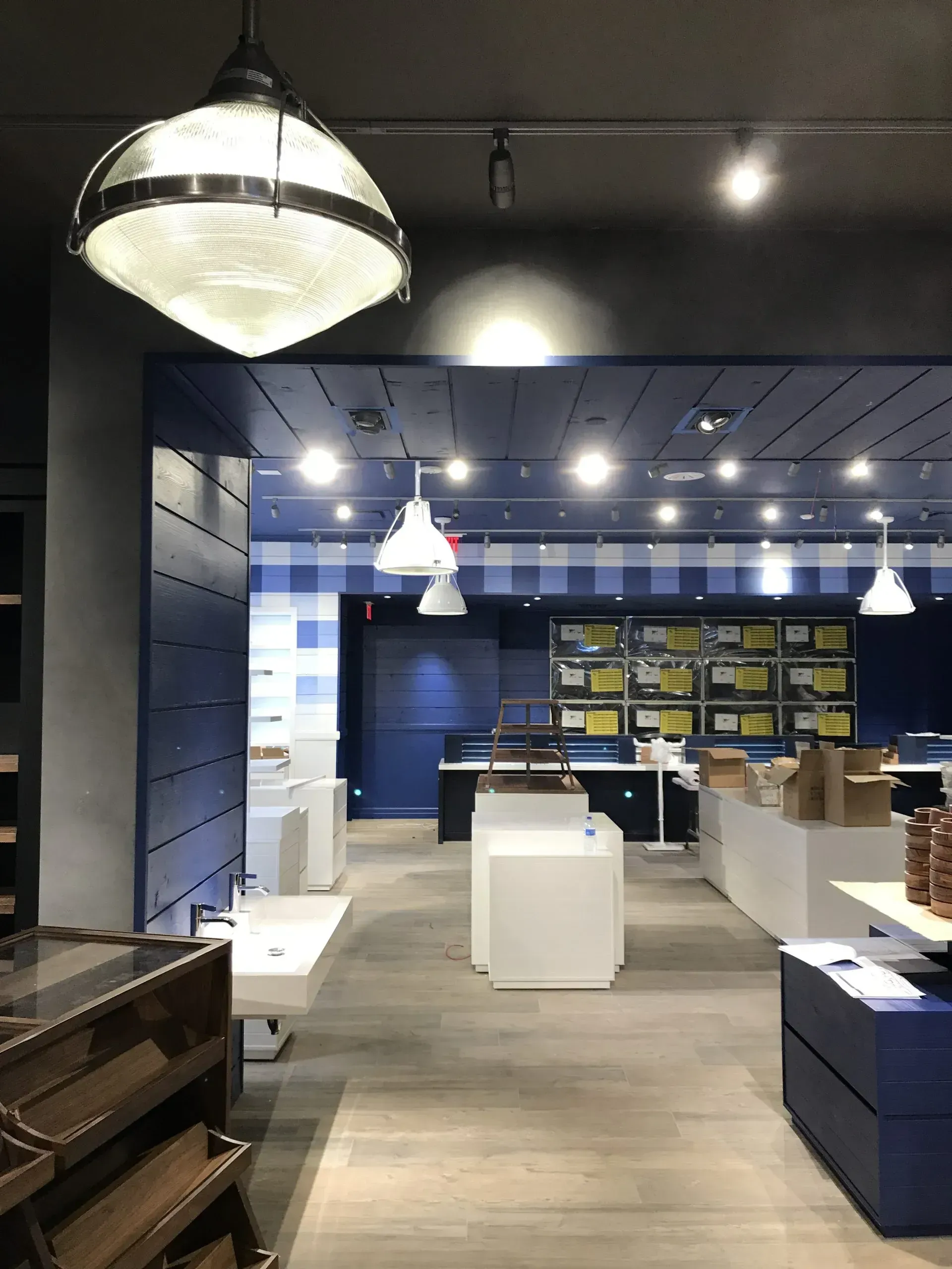 Interior of a Bath & Body Works store with blue and white accents, white displays, and overhead lighting.